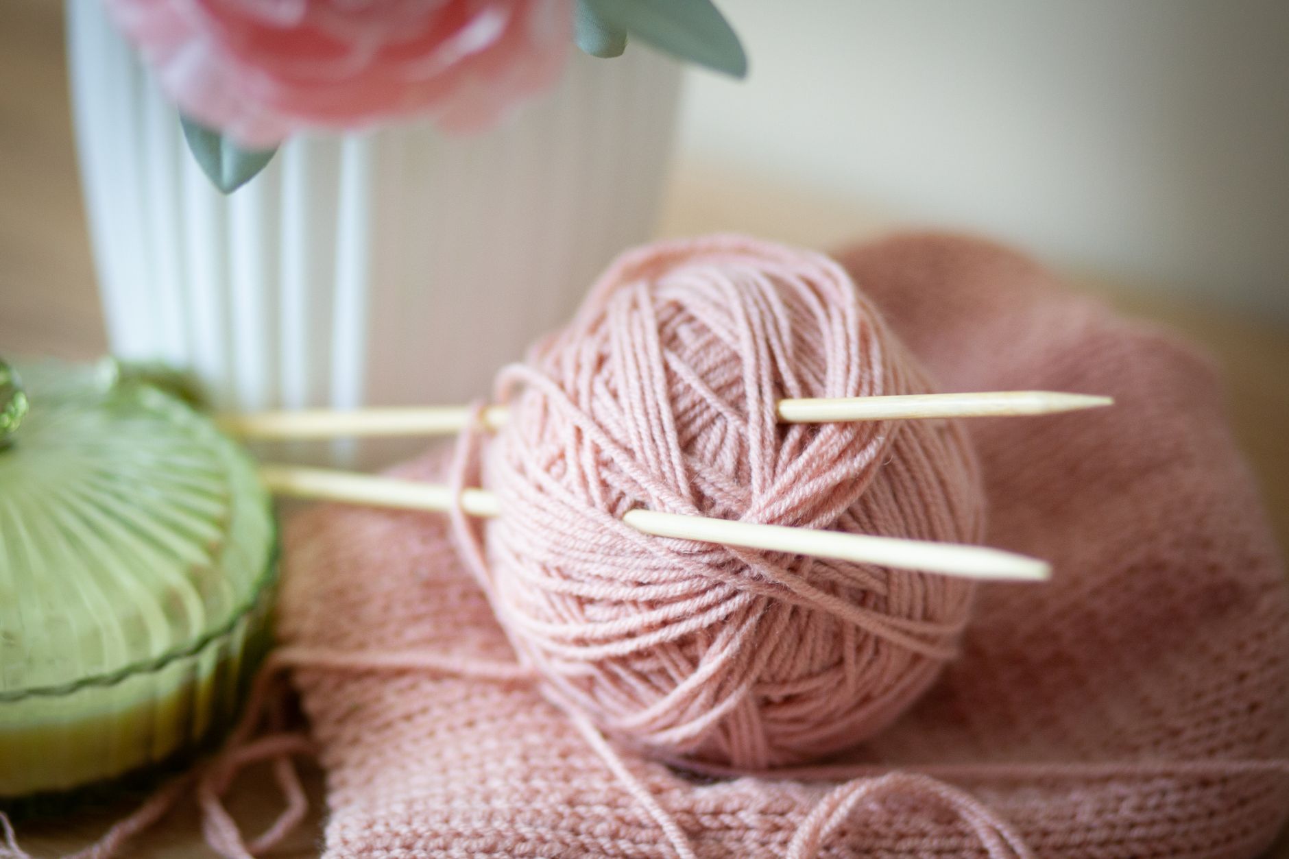 Pelote de laine rose et aiguilles en bambou pour se mettre au tricot